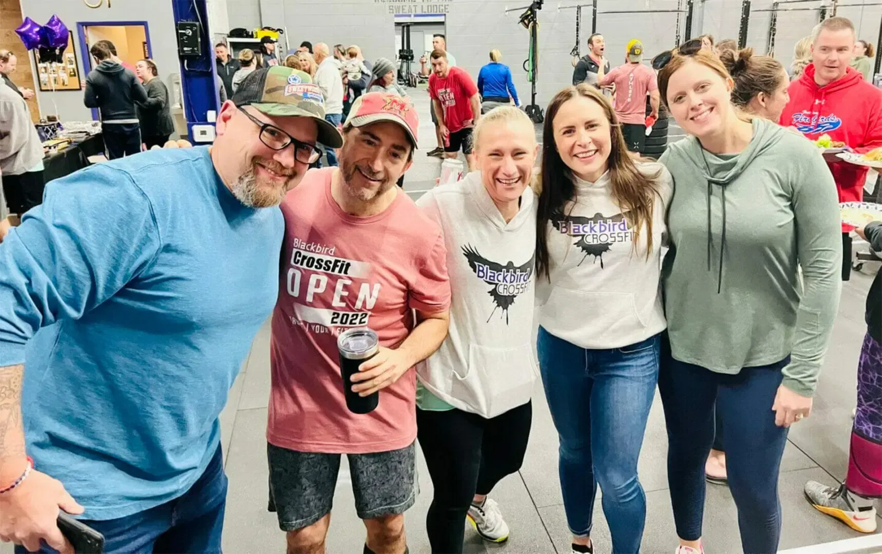 A group of people are posing for a picture in a gym.