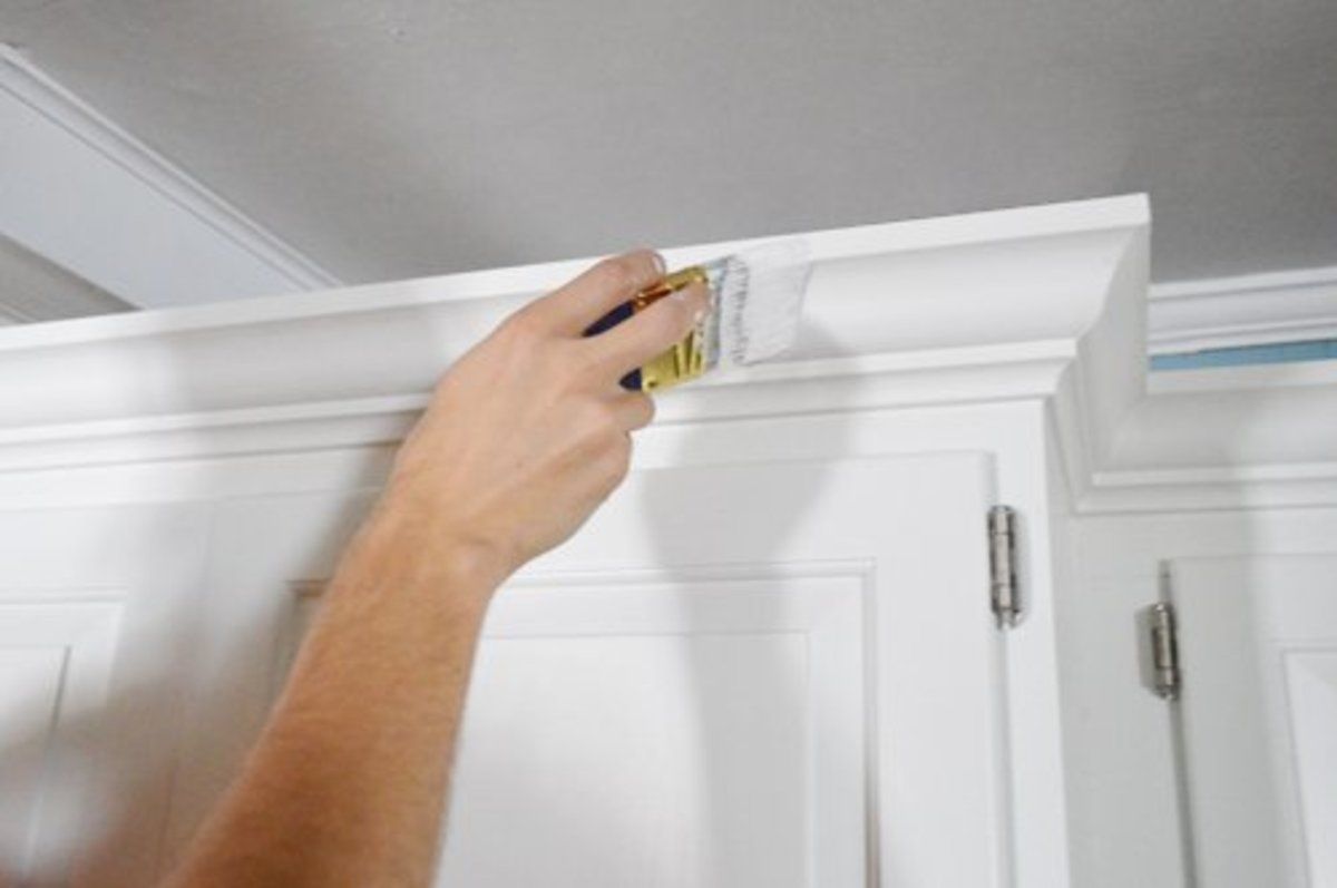 A man is working on a wall in a room.