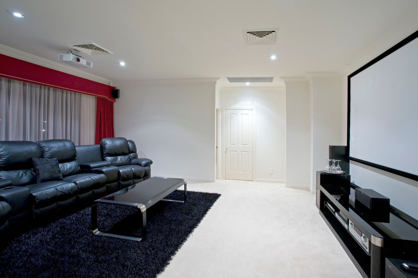 A living room with a projector screen and a couch.