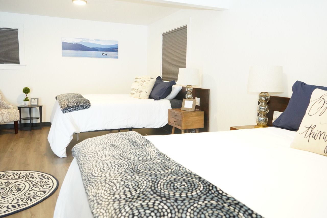 a bedroom with two beds , a chair and a rug .