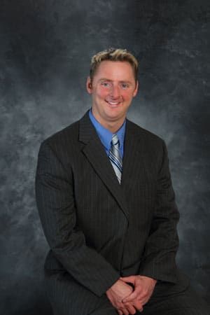 A man in a suit and tie is smiling for the camera