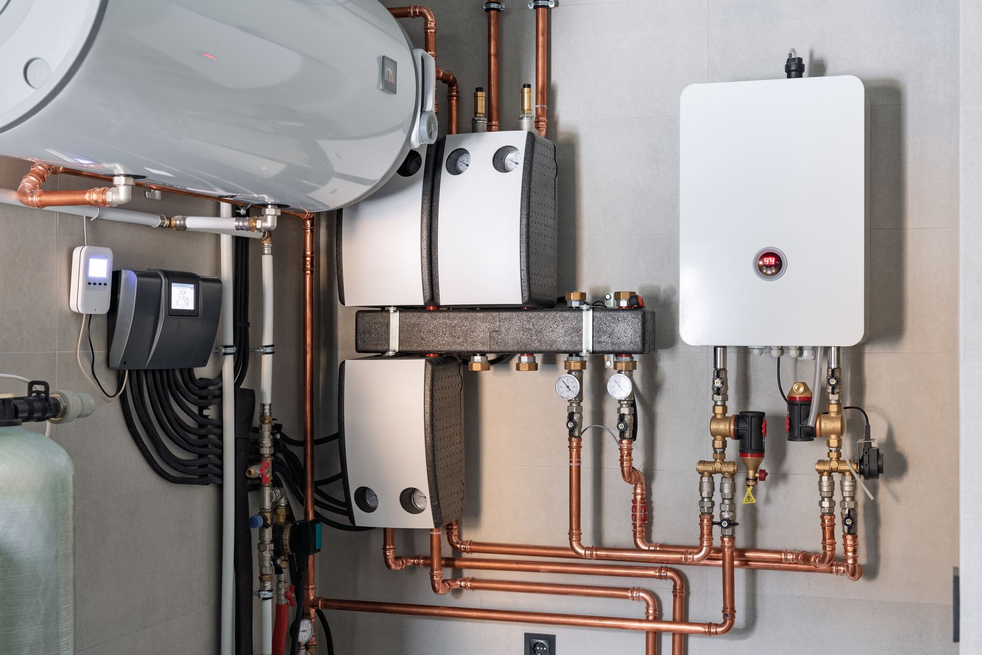 Complex copper pipe system with water heater and other equipment attached to a wall.