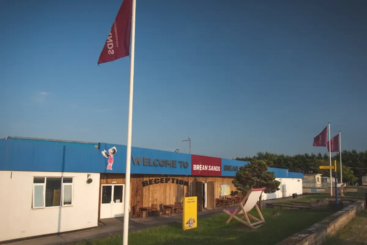 A pepperoni pizza is in a box on a table.