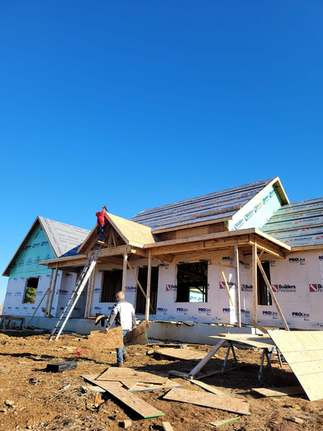 A Man Is Standing In Front Of A House Under Construction - Owingsville, KY - Withrow Builders