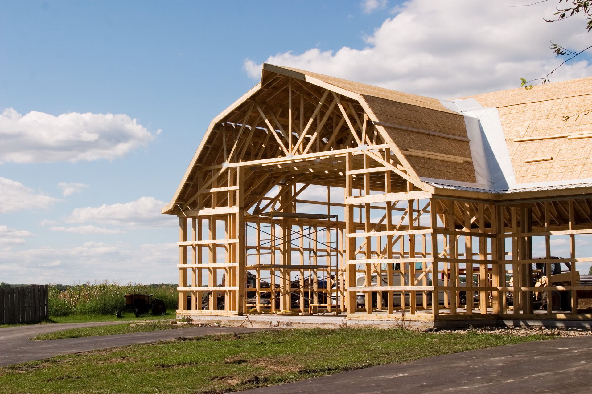 A Large Wooden Barn Is Being Built On A Lush Green Field - Owingsville, KY - Withrow Builders