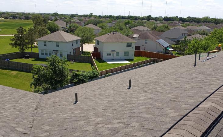 A rooftop view of a residential area with houses and trees.