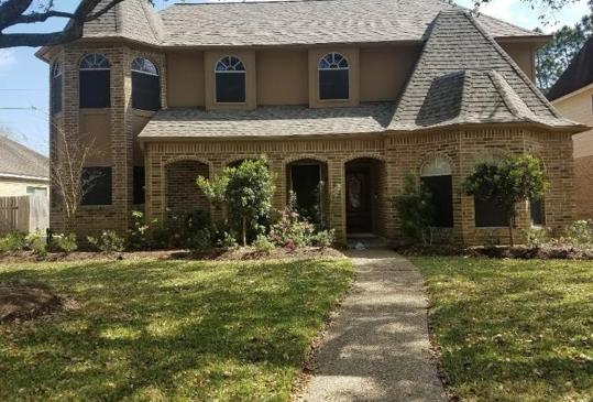 A large brick house with a walkway leading to it.