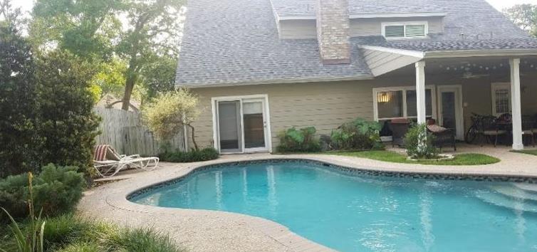A large house with a swimming pool in front of it.