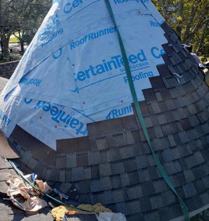 A dome shaped roof with shingles being installed on it.