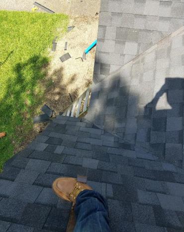 A person is standing on top of a roof.