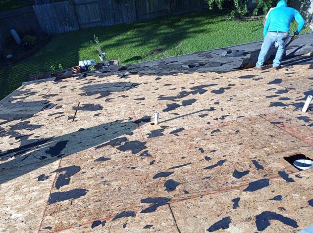 A man is working on a roof with a lot of shingles on it.