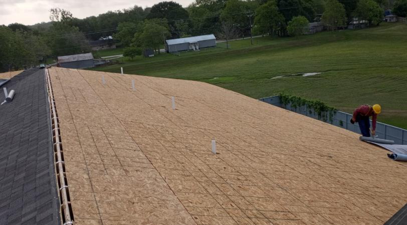 A man is working on the roof of a building.