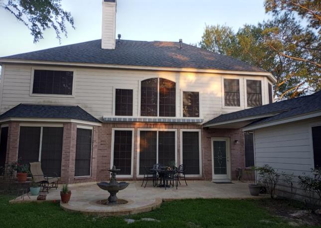 A large house with a patio and a fountain in the backyard.