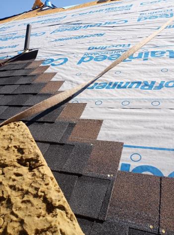 A close up of a roof with shingles being installed.