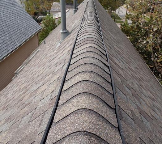 A close up of a roof with shingles and chimneys