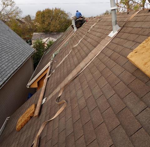 A man is working on the roof of a house