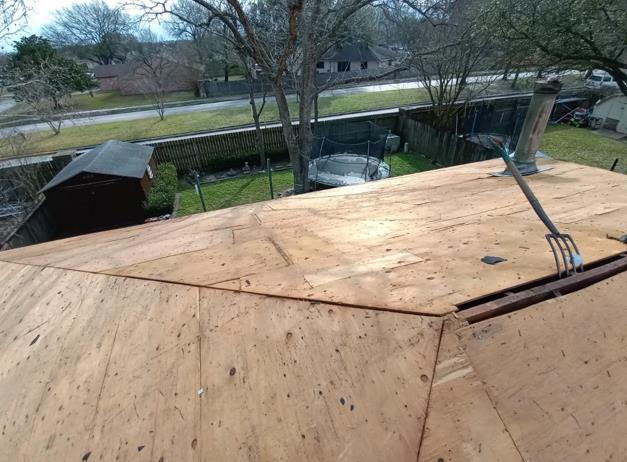 A fork is sitting on top of a wooden roof.