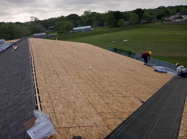 A man is working on the roof of a building.