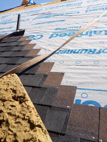 A close up of a roof with shingles being installed.