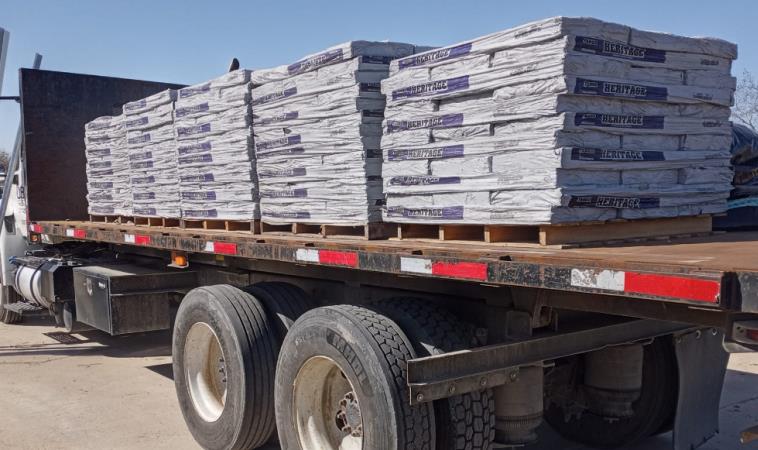 A semi truck is carrying a load of bricks on a flatbed trailer.