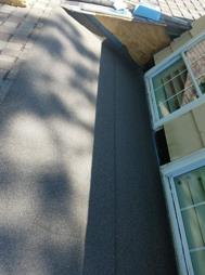 A close up of a roof with a window on it.