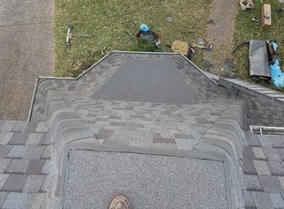 A person is standing on the roof of a house.