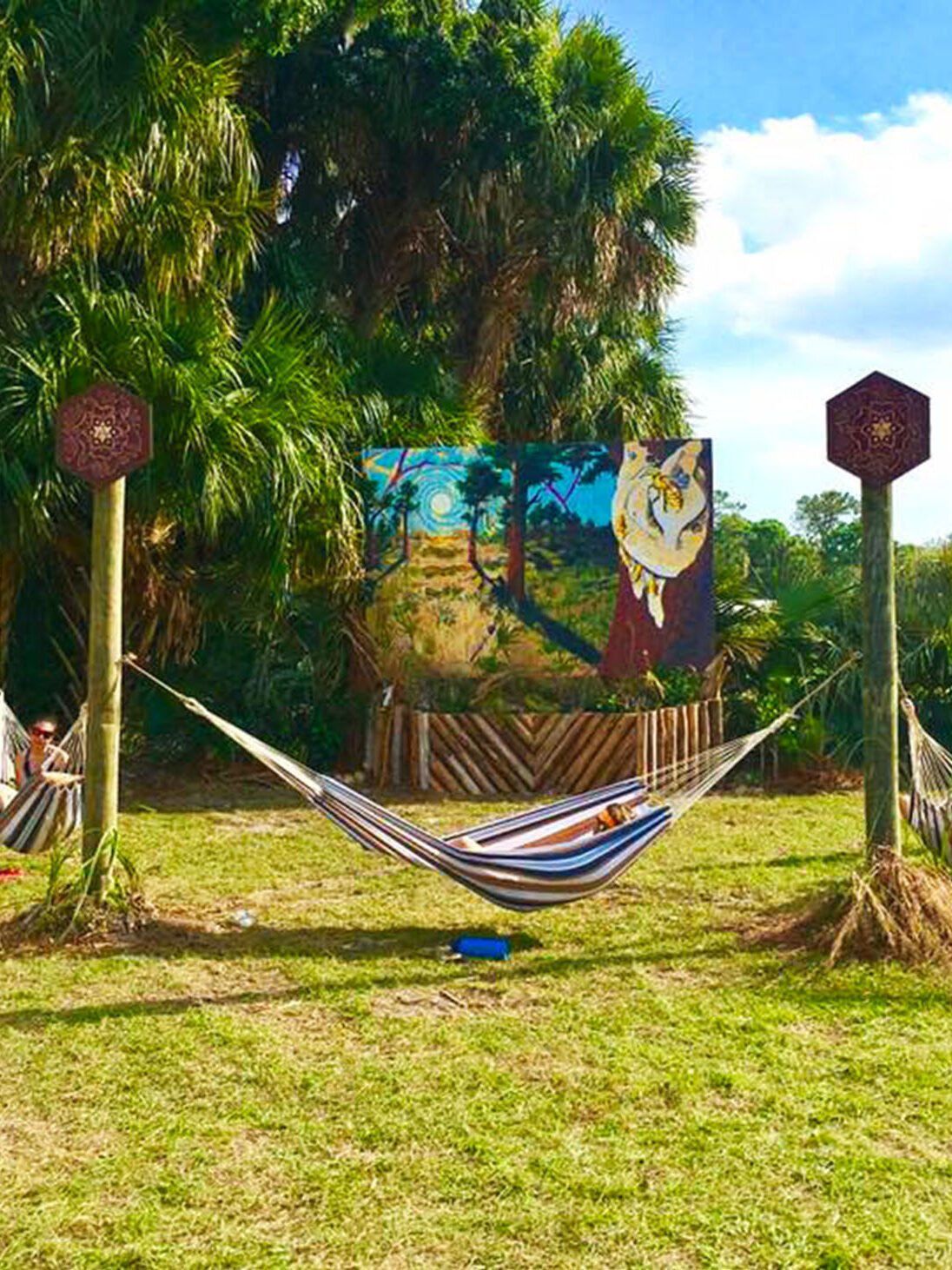 Bee Aware mural at the Okeechobee Music Festival. Created by heartspace art, this mural has a message about the importance of bees in our ecosystem. This photo shows the entire installation including the hammock hang out.