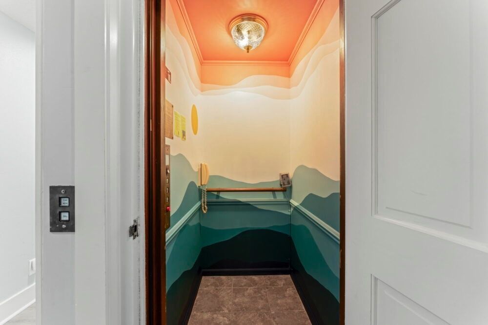 This hand painted acrylic mural was created for a short term rental located in palm coast, central beach, St. Augustine Florida. It features an abstract, minimal, pink, orange, and blue ocean sunset. The top and bottoms are an ombre of colors with the orange sun setting on the left side. The mural was painted inside the elevator of the rental.