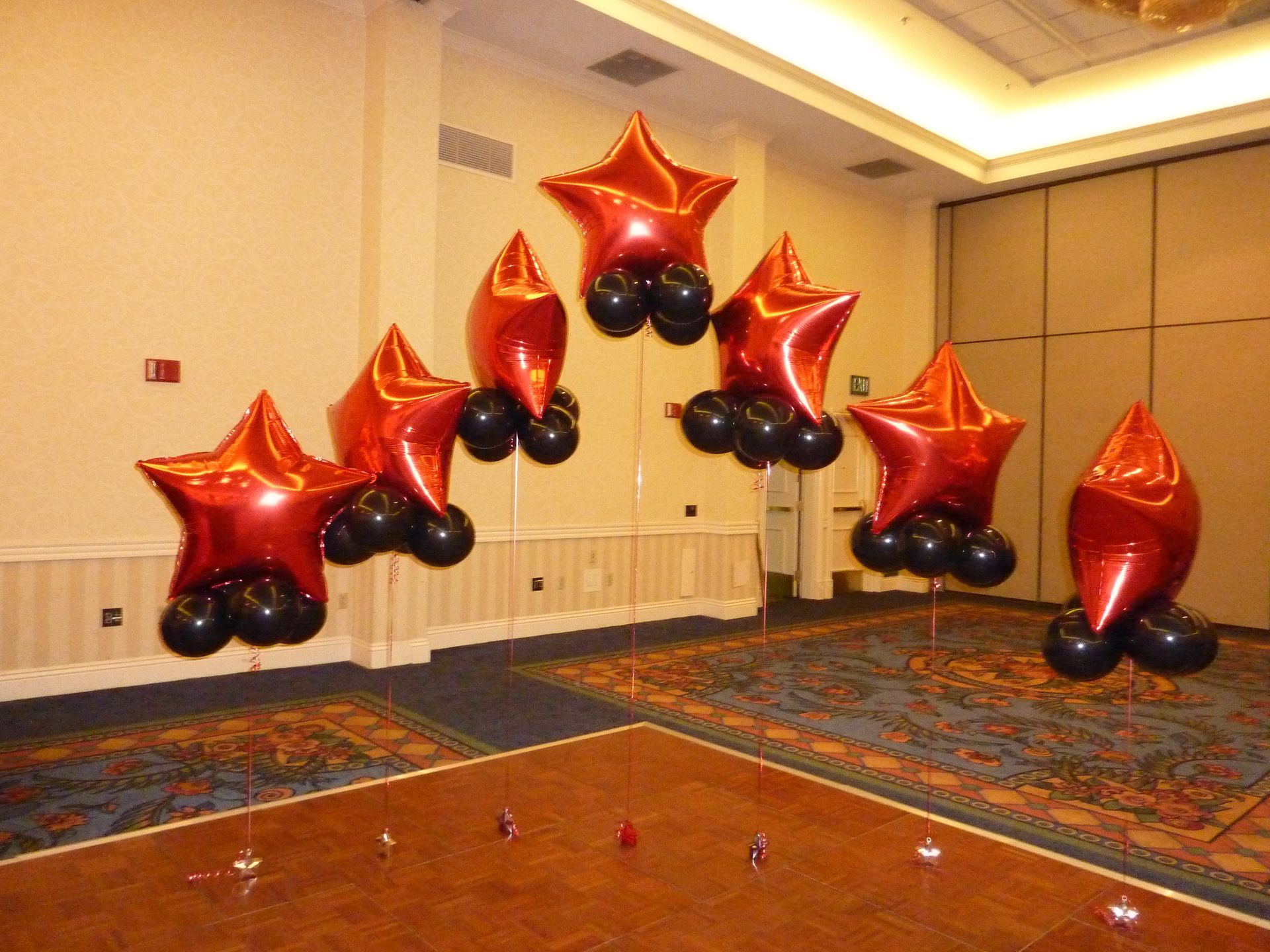 A room with red and black balloons in the shape of stars