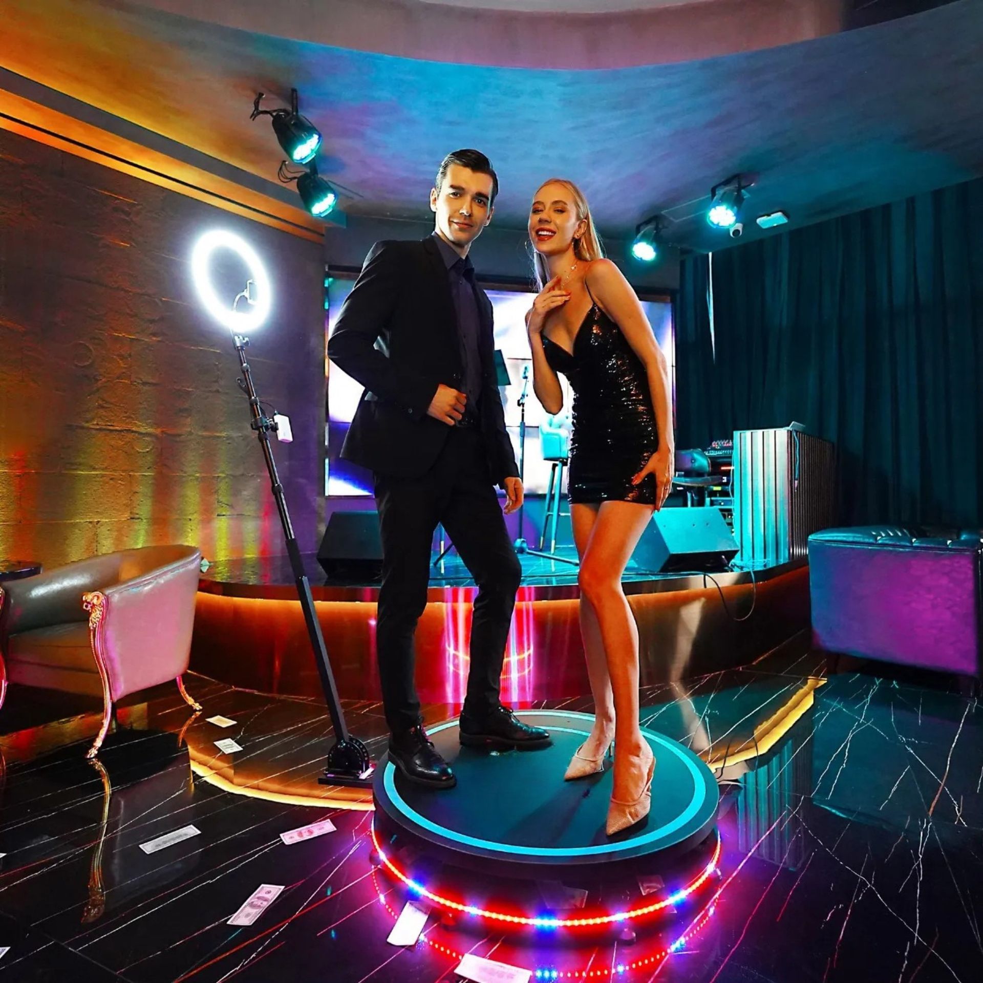 A man and a woman are standing on a stage in a room.