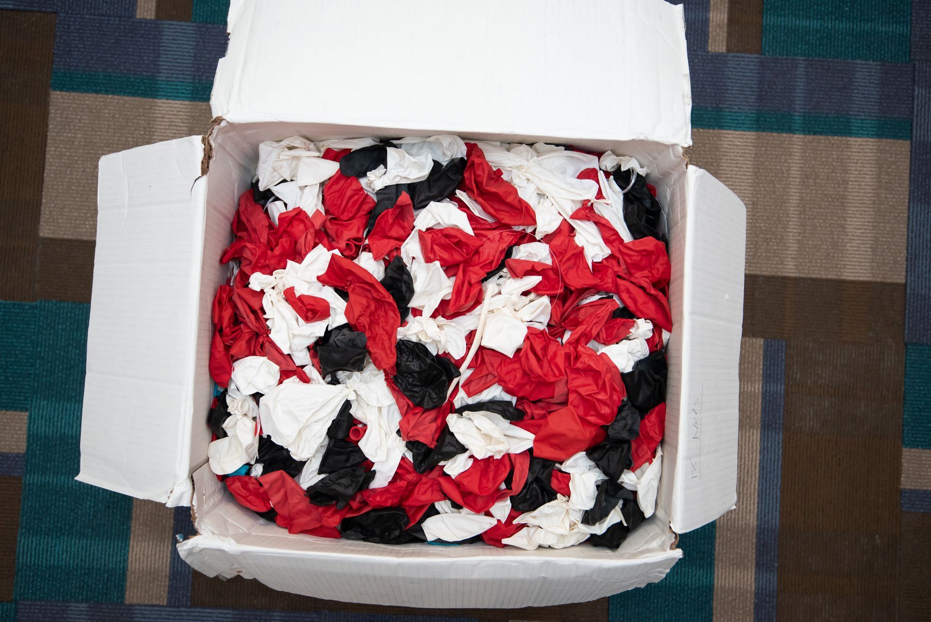 A white box filled with red , white and black tissues
