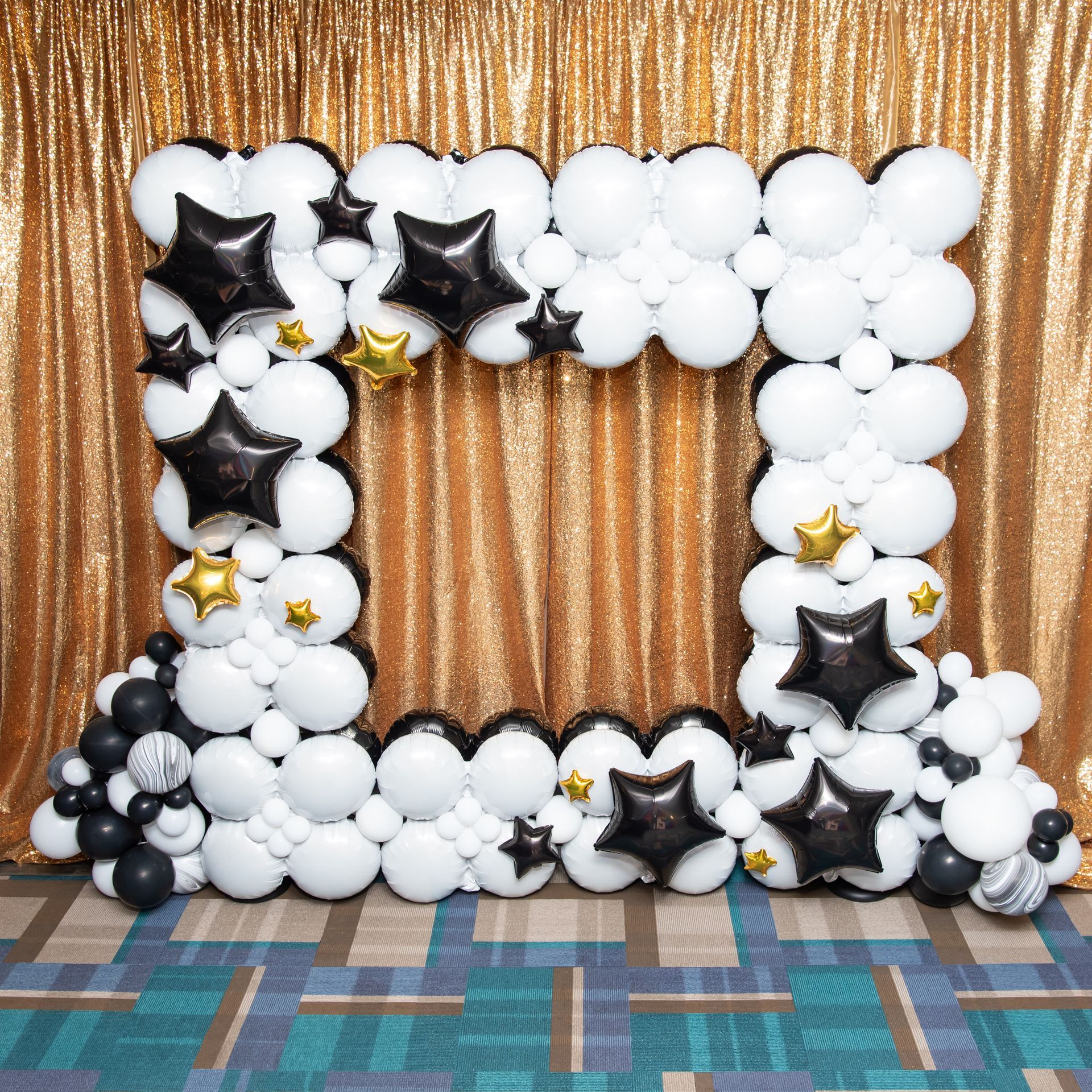 A picture frame made of black and white balloons and stars.