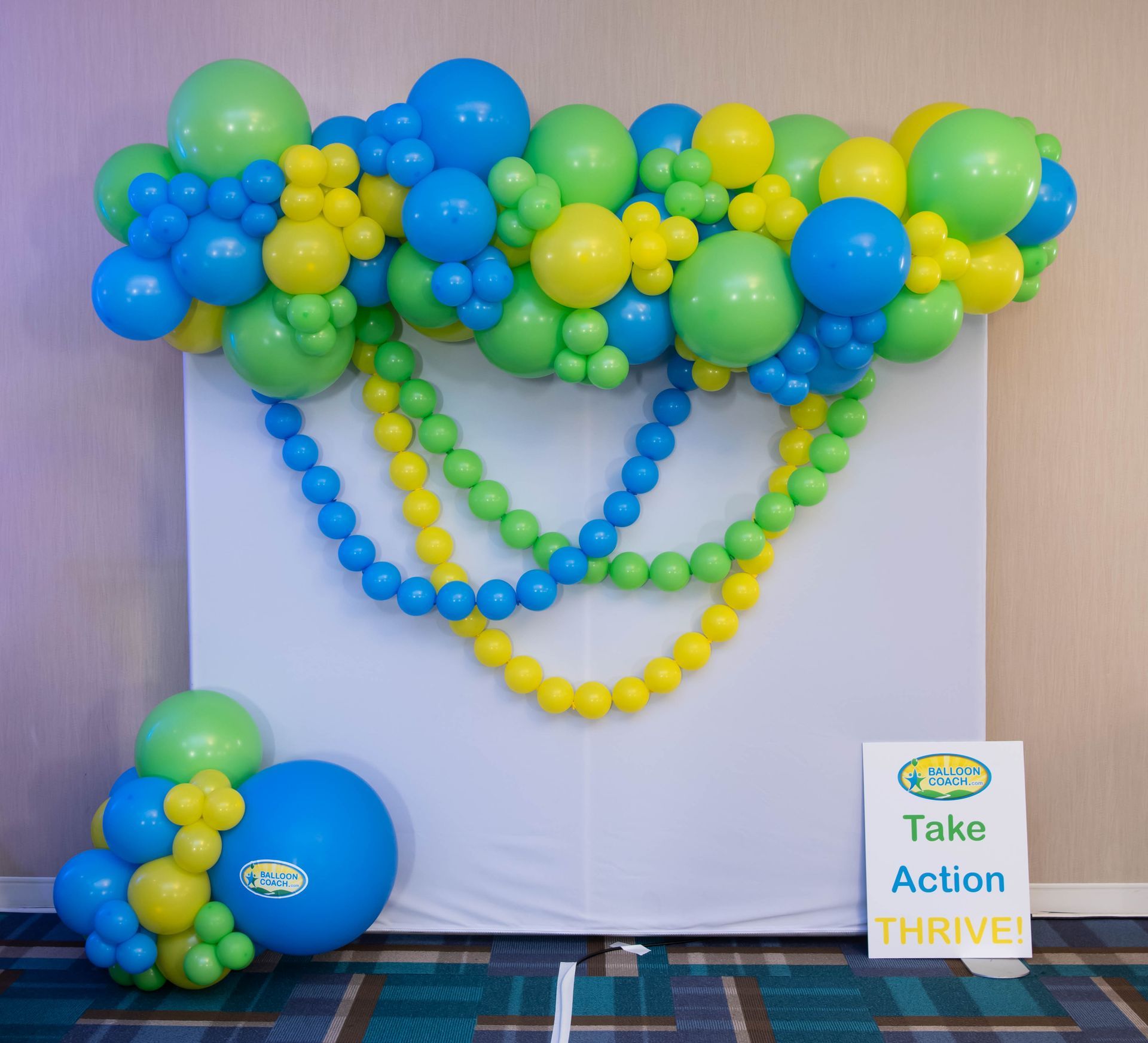 A sign that says take action thrive is surrounded by balloons