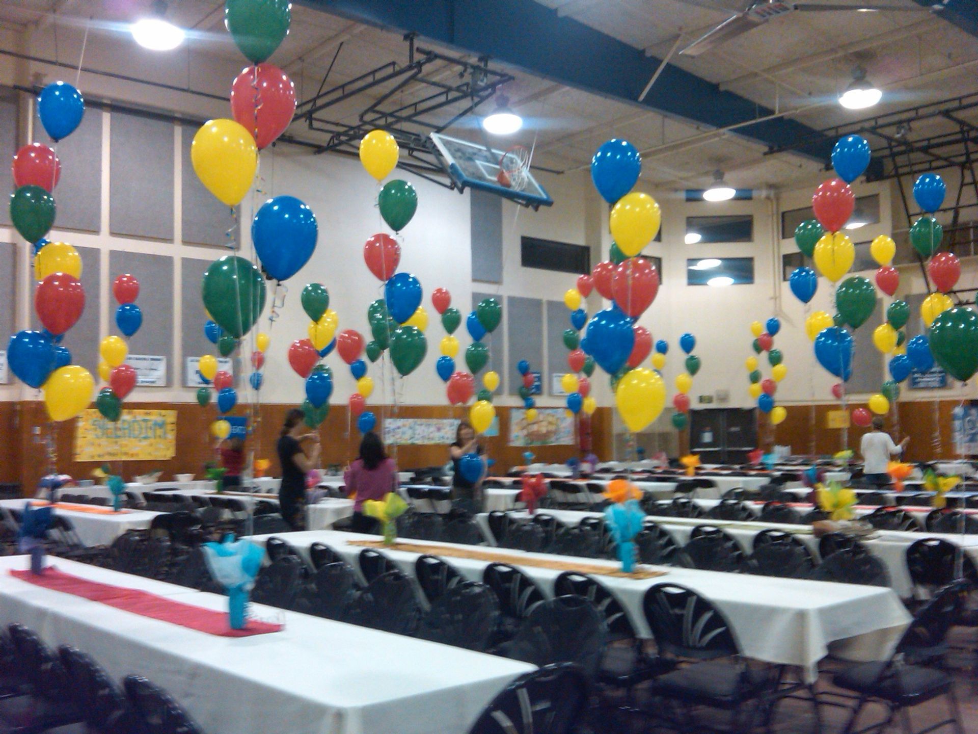 A large room with tables and chairs decorated with balloons