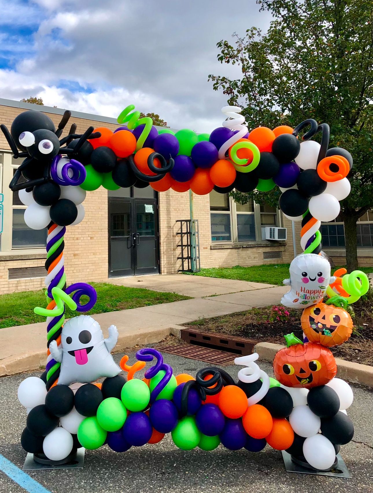A picture frame made of balloons for halloween is sitting in front of a building.