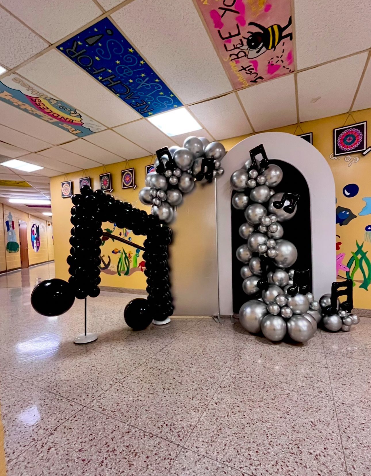 A music note made out of balloons in a hallway