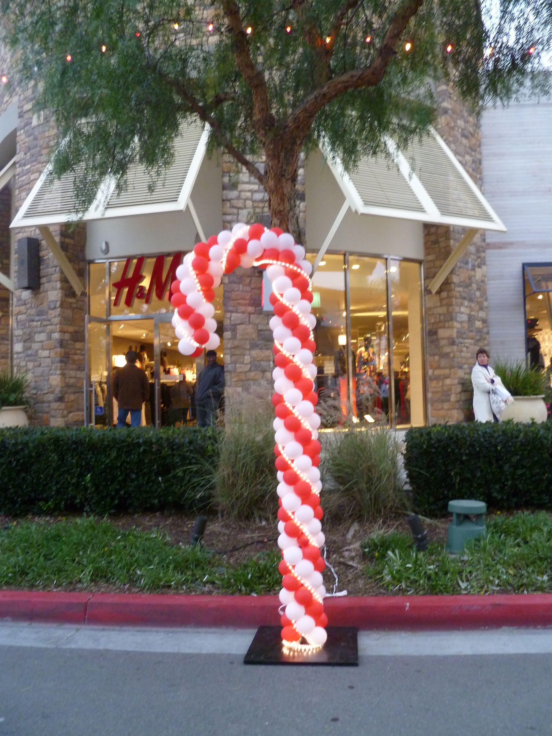 A large candy cane made of red and white balloons