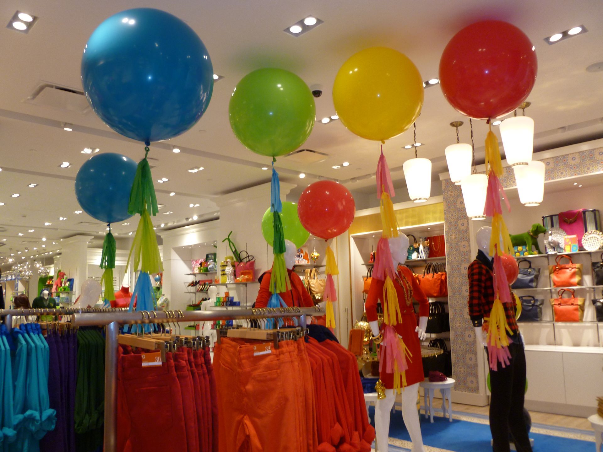 Colorful balloons hang from the ceiling in a store