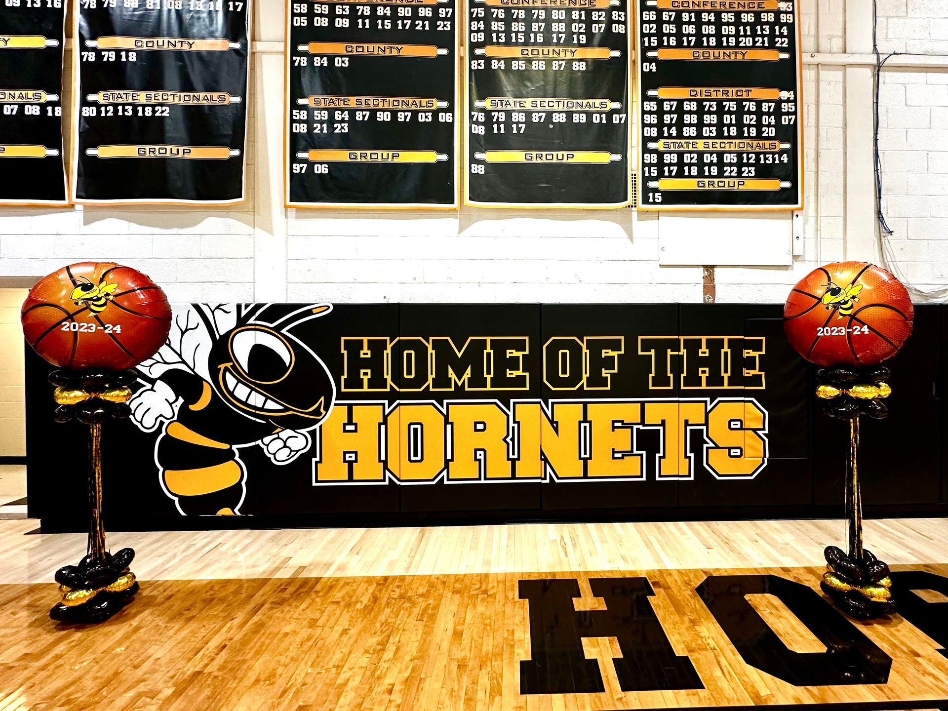 A basketball court with a sign that says home of the hornets