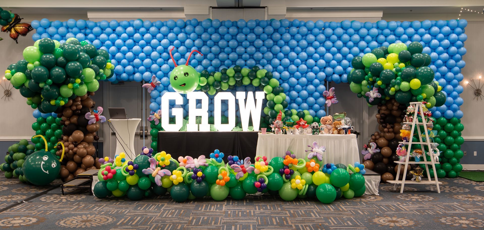 A room filled with balloons and a sign that says `` grow ''.