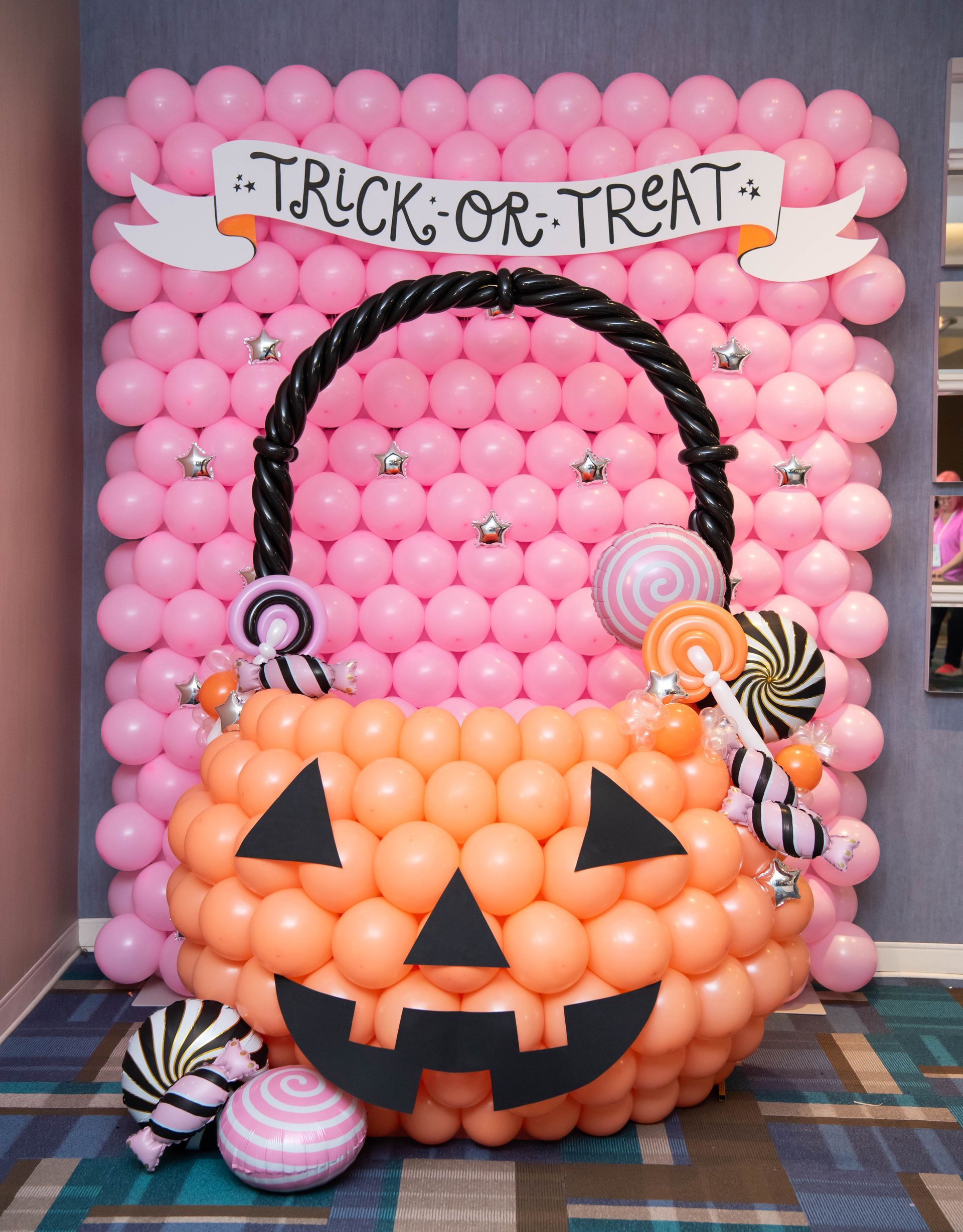 Pink and orange balloon Halloween display. A pumpkin basket with