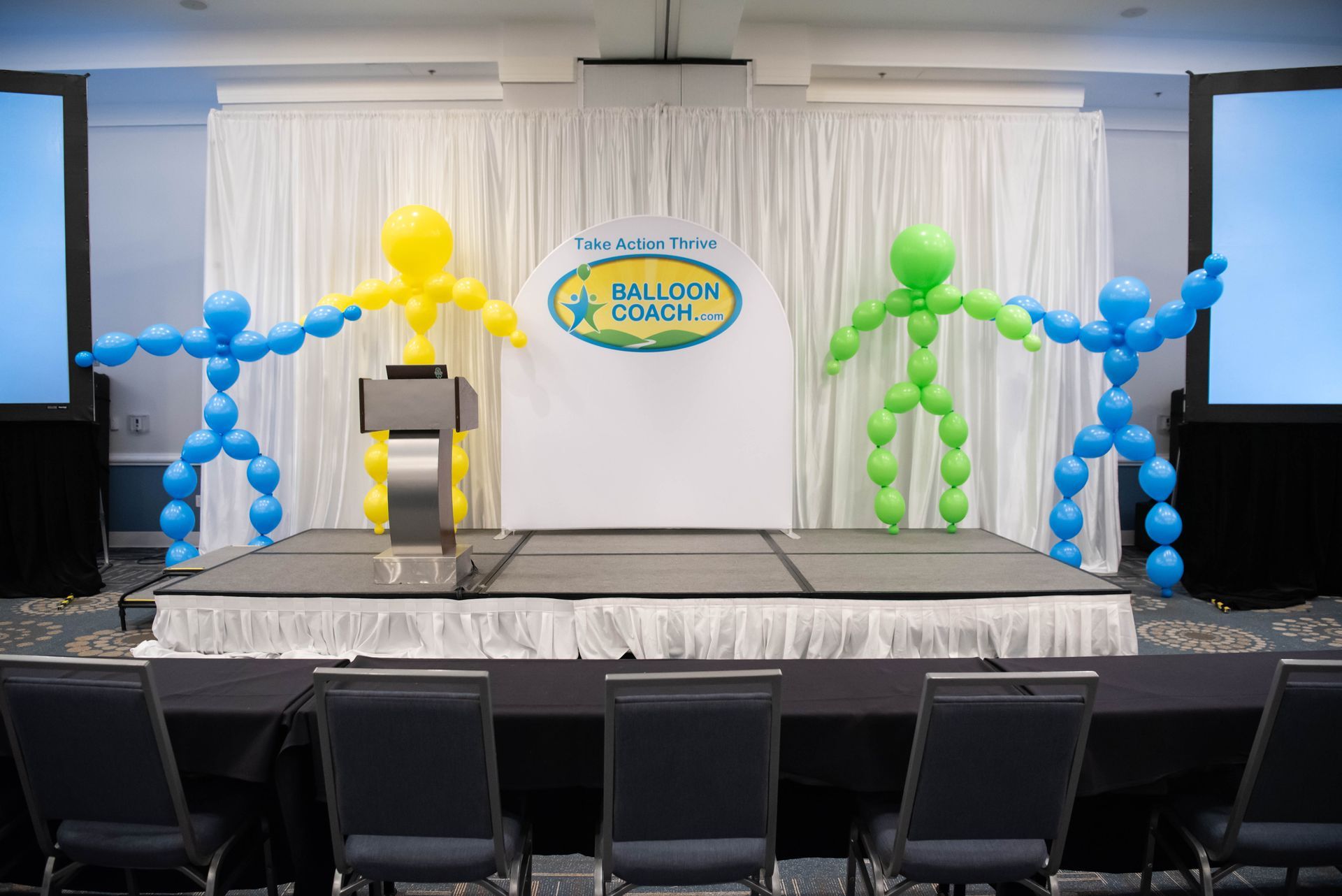 A stage with balloons in the shape of people on it