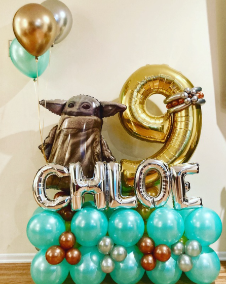 Birthday balloon arrangement featuring a Grogu foil balloon, the name Chloe, a gold number 9, and various colored balloons.