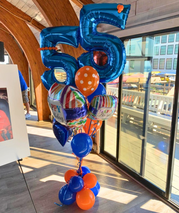 Blue and orange balloon arrangement for a 55th birthday celebration. Includes number balloons, and other shapes.