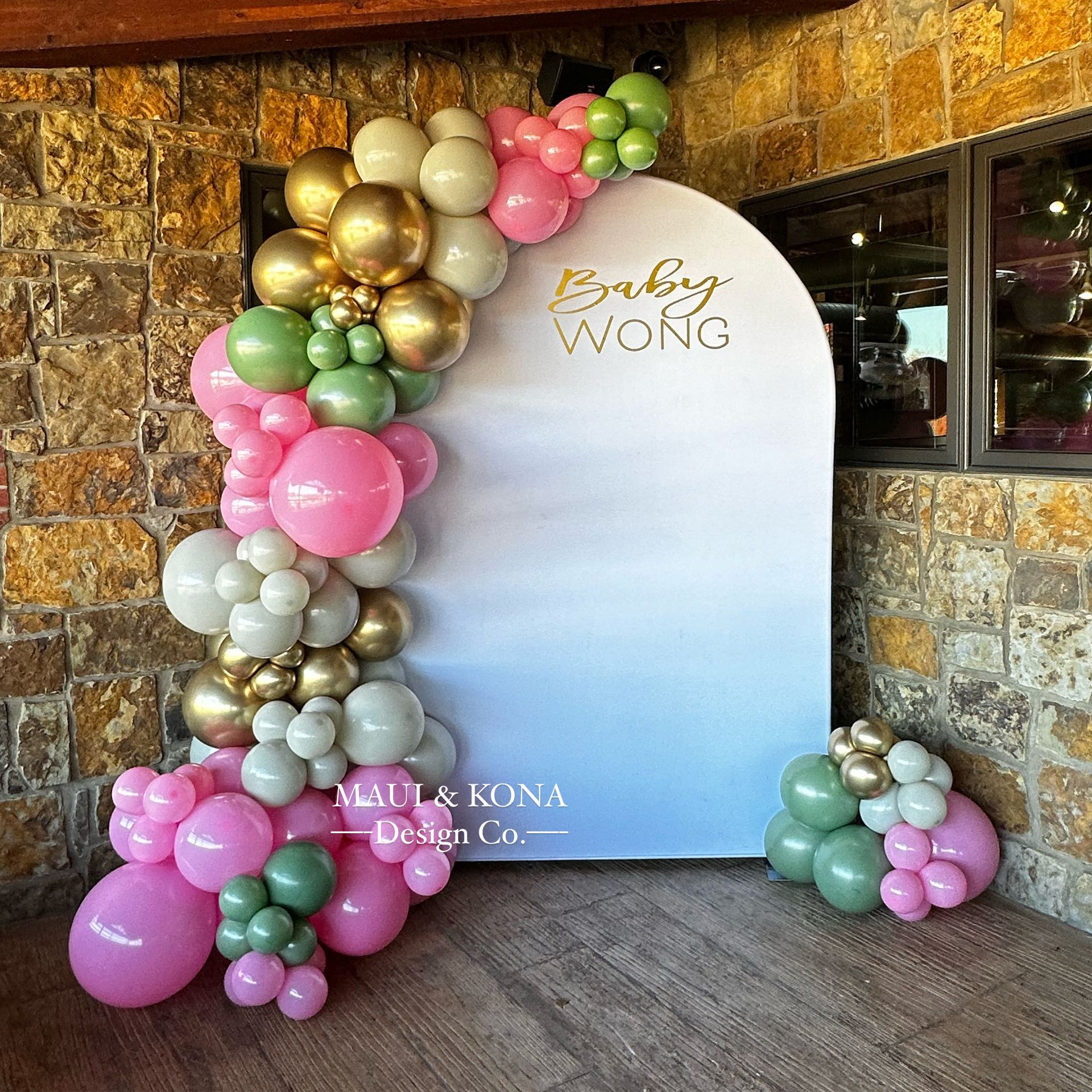 A wall with balloons on it that says baby wong