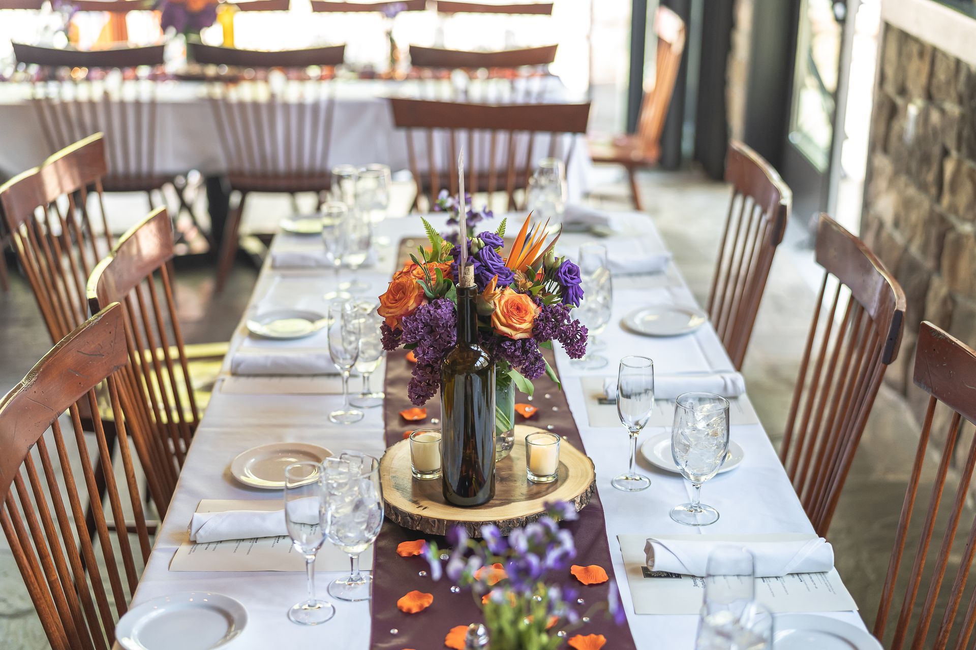 Formal dining table set with white linens, flowers, and place settings.
