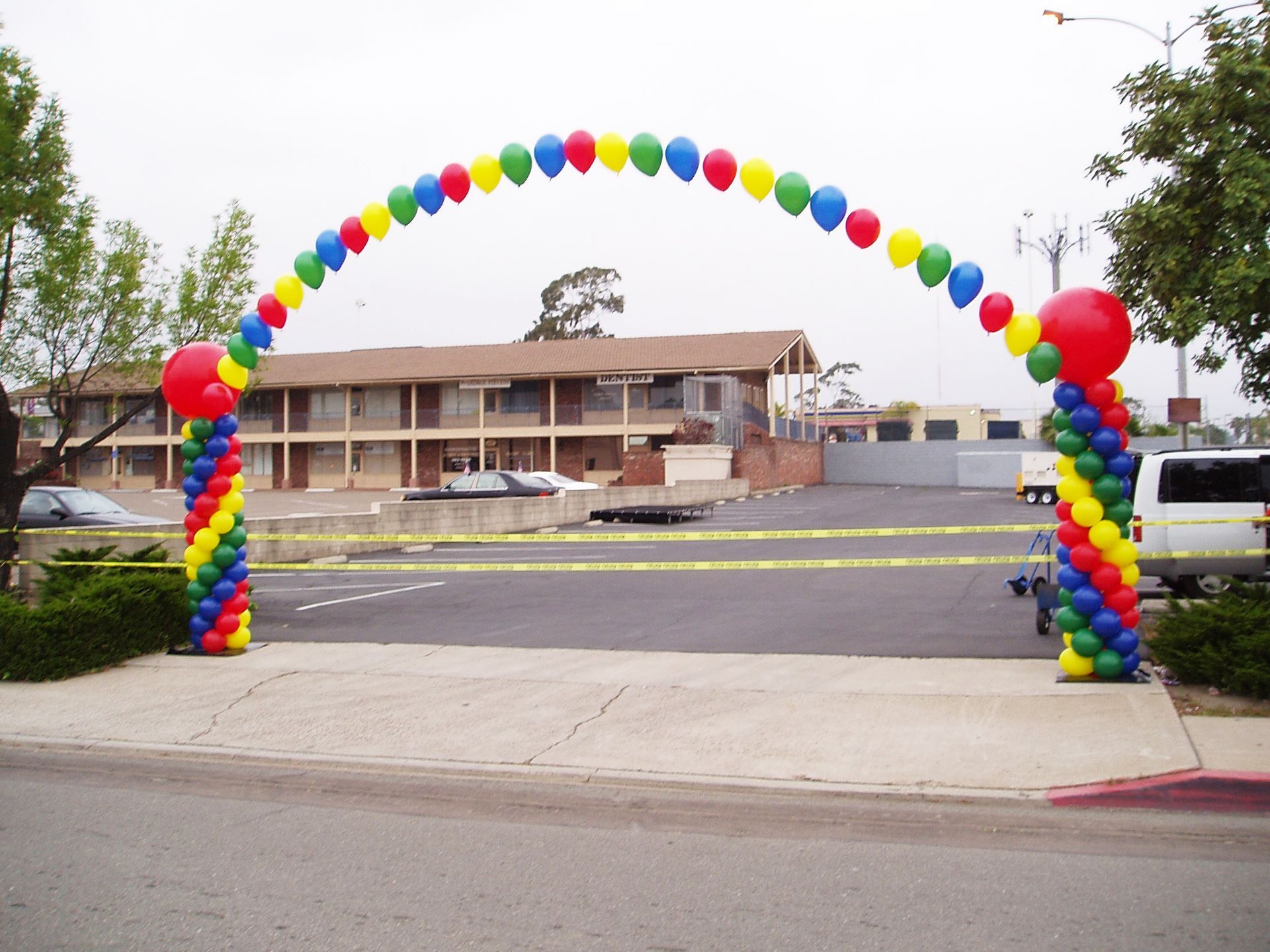 A rainbow colored balloon arch in front of a building