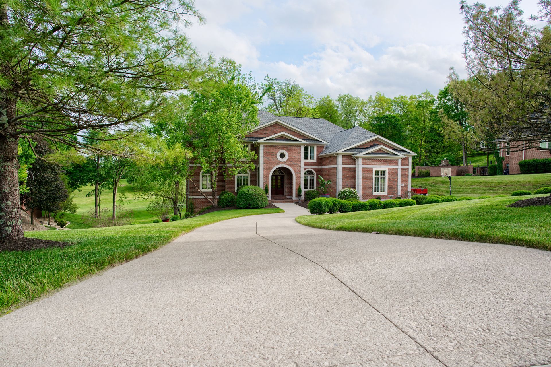 A large brick house with a driveway leading to it