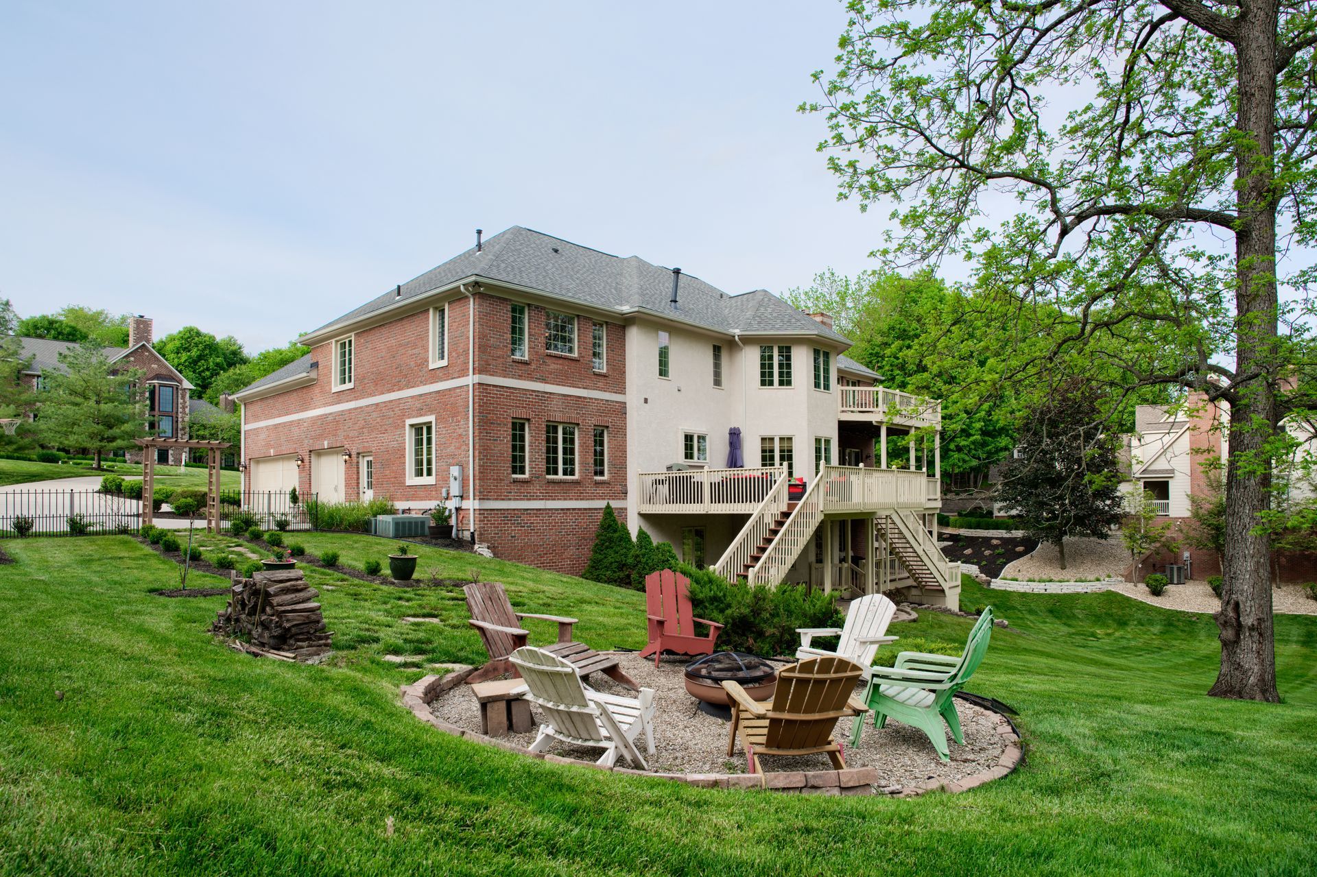 A large brick house with a fire pit in the backyard.