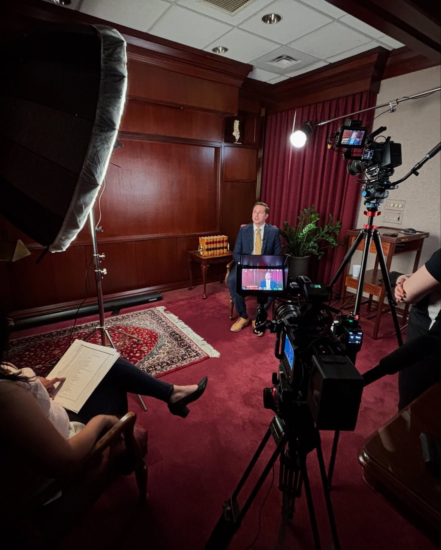 A camera is sitting on a desk in front of a computer monitor
